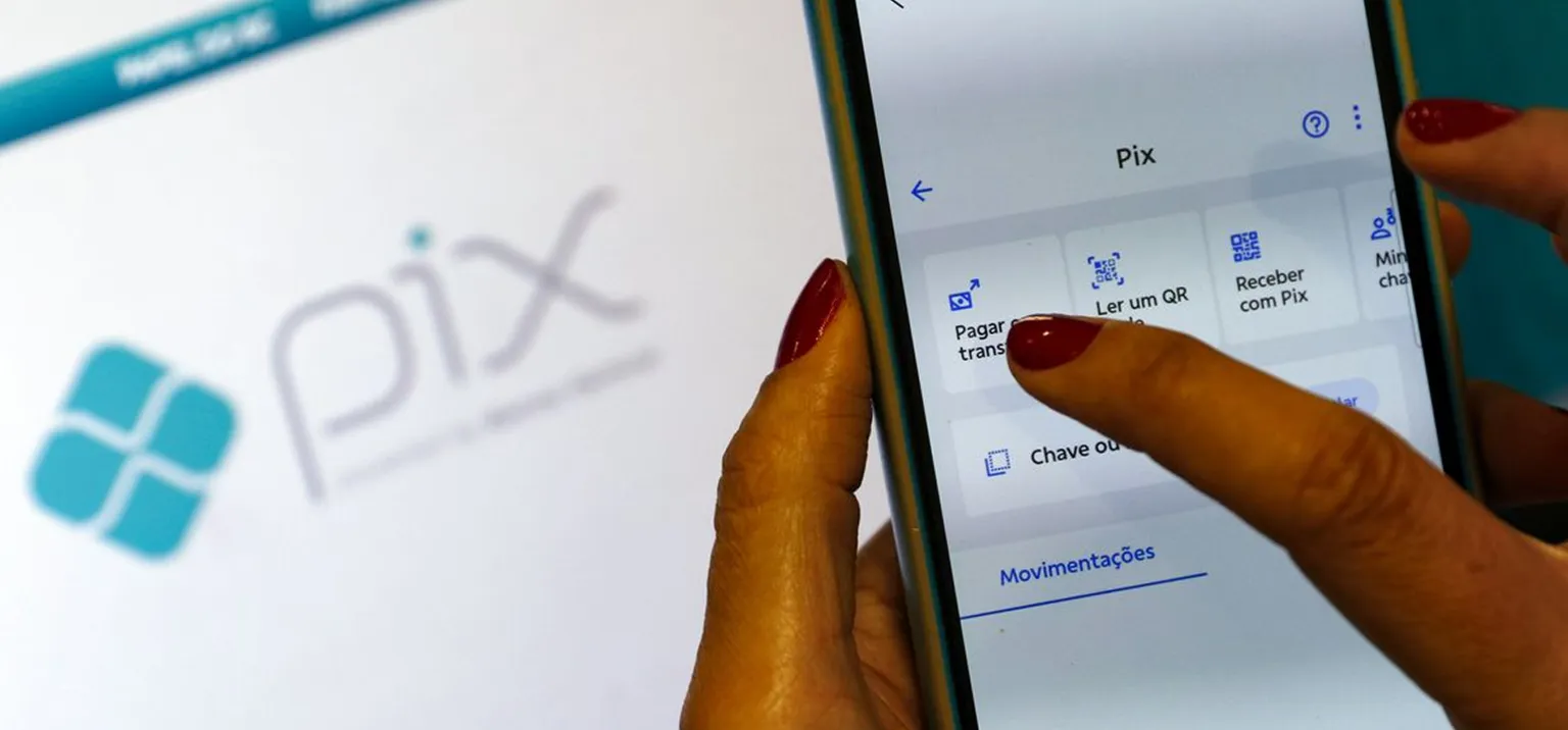 Phone showing the Pix app with the Pix logo behind it Phone showing the Pix app with the Pix logo behind it